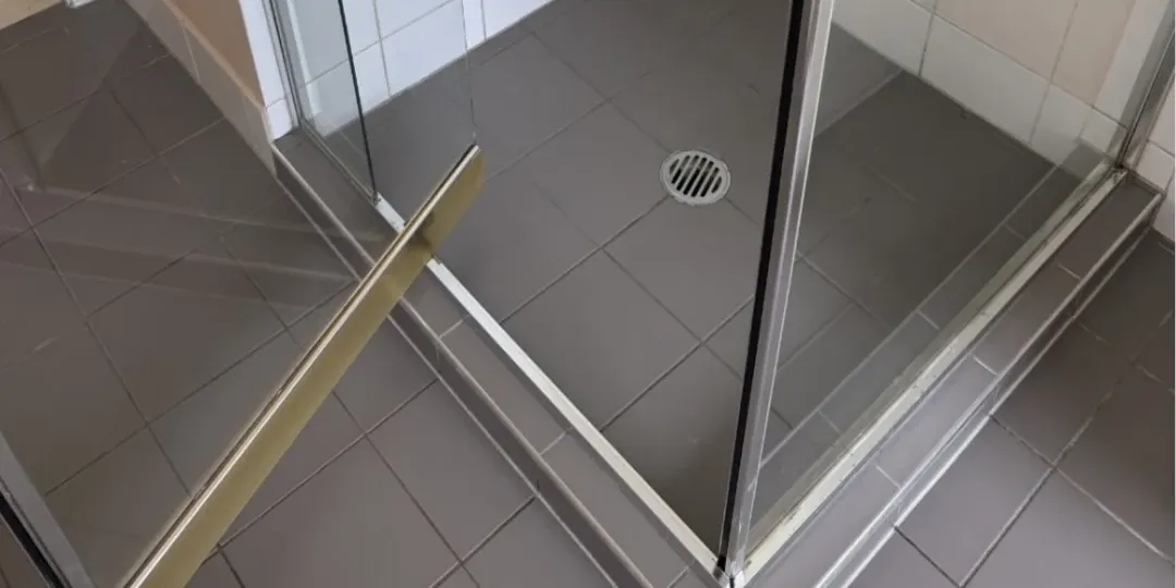 After: the same shower base, screen and door track, clean