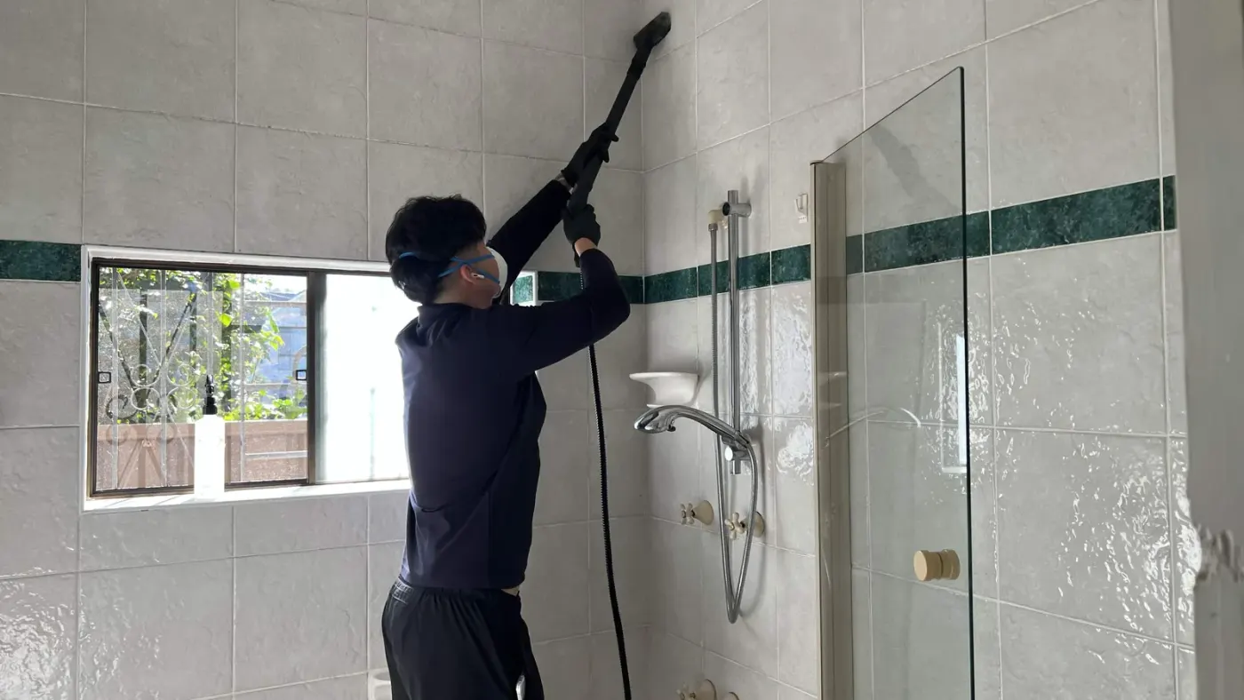 Steam cleaning the grout on a shower wall